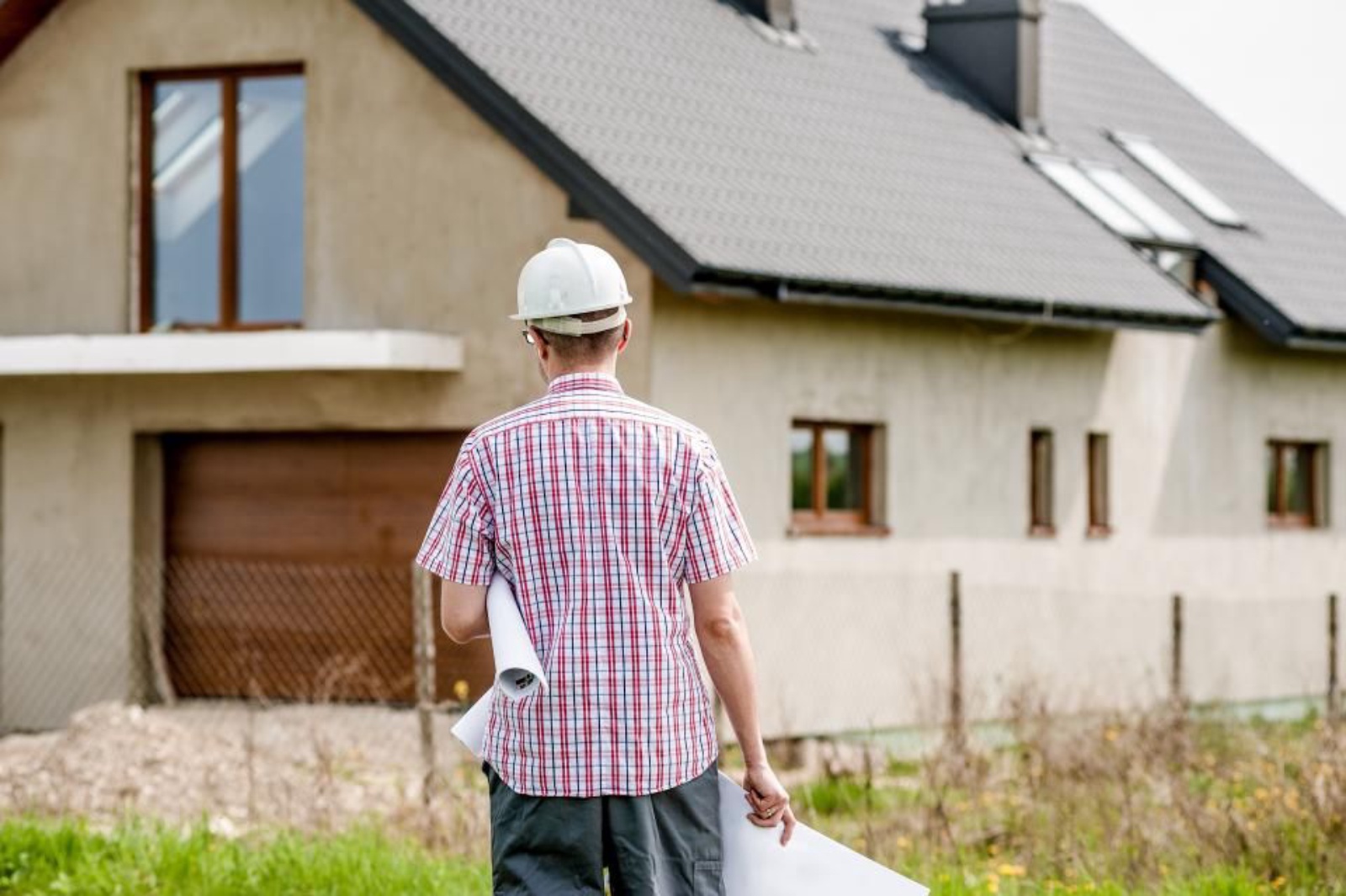 Artisan devant une maison en construction
